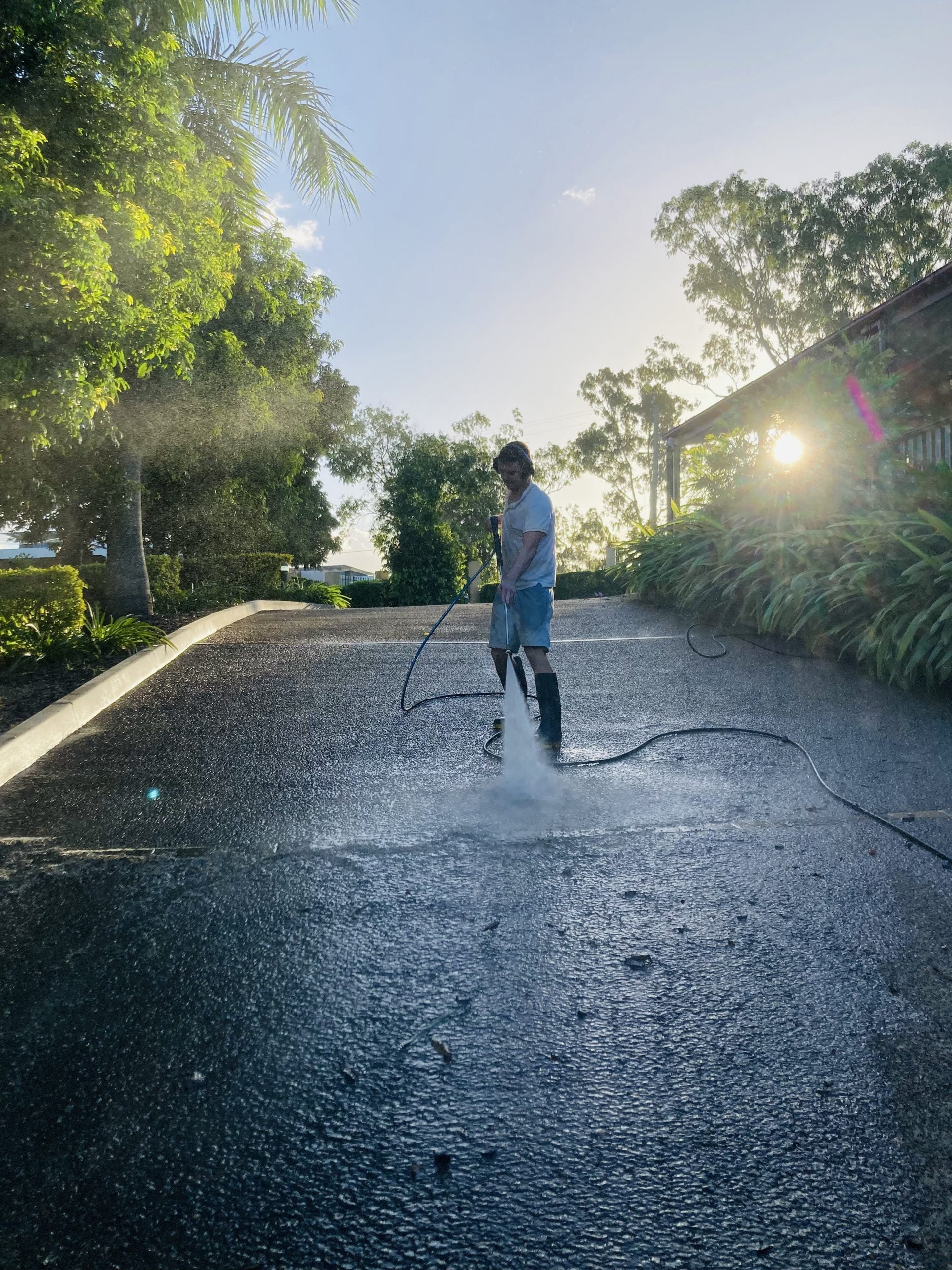 rinsing a driveway with a pressure cleaner