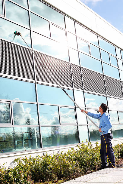 A man demonstrating how to clean windows with a water fed pole